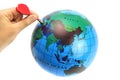 The dart in the hand aimed at the globe is isolated on white