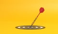 Dart hitting a target on the center on yellow background with copy space Royalty Free Stock Photo