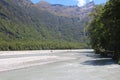 Dart River with people in the distance who do rafting along the river, New Zealand Royalty Free Stock Photo