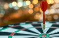 Dart target arrow on bullseye over bokeh background