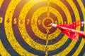 Dartboard with arrow at center after many times attempt. Royalty Free Stock Photo