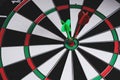 Dartboard with green dart stuck in center Royalty Free Stock Photo