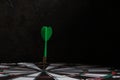 Dartboard with green dart stuck in center Royalty Free Stock Photo