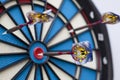 Dartboard with three darts, one hit bullseye with some selective focus