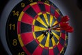 darthboard, red and yellow, with three red darts in the center