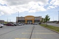 Looking across the parking lot to a Lawtons pharmacy and customers coming and going