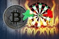 Darts arrow on dartboard with golden bitcoin wooden with flames and smoke dust Royalty Free Stock Photo