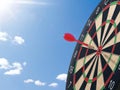 Darts with dartboard with blue sky background concept for hitting target, goal and success Royalty Free Stock Photo