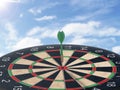 Darts with dartboard with blue sky background concept for hitting target, goal and success Royalty Free Stock Photo