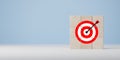 Darts target aim icon on wooden cubes with blue background. Business goal and success concept. Focus on goal and achieve