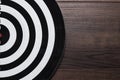 Darts target on dark wooden background