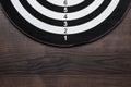 Darts target on dark wooden table