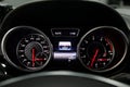 The dashboard of the car is glowing blue and red at night with a speedometer, carbon and tachometer and other tools to monitor the
