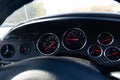 The dashboard of the car with red arrows and carbom trim, a speedometer, tachometer and other tools to monitor the condition of