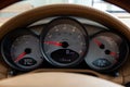 Dashboard is covered in beige genuine leather of a sports car brand Porsche with instruments speedometer and tachometer displays