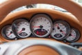 Dashboard is covered in beige genuine leather of a sports car with instruments speedometer and tachometer displays are highlighted Royalty Free Stock Photo