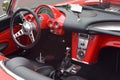 the dashboard of a red, classic car with a black steering wheel Royalty Free Stock Photo