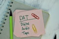 DAT - Digital Audio Tape write on sticky note isolated on Wooden Table