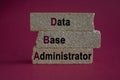 Data Base Administrator symbol. DBA acronym on brick blocks with letters. Beautiful red background. Data Base Administrator or