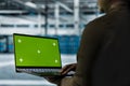 Data center admin conducts tests on infrastructure using green screen laptop Royalty Free Stock Photo