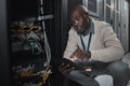 Data center or black man on tablet in server room on database maintenance or software update. Cybersecurity, it or Royalty Free Stock Photo