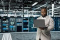 Data center software developer running error checking utilities on laptop, Royalty Free Stock Photo
