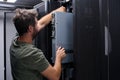 Data center technician installing server hardware in a rack cabinet during routine maintenance and upgrade Royalty Free Stock Photo