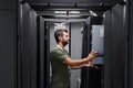 Data center technician installing server hardware in a server rack performing IT maintenance Royalty Free Stock Photo