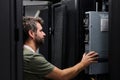 Data center technician performing server maintenance in a rack-filled server room Royalty Free Stock Photo