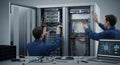 Data Center Technicians Installing Network Hardware with Cables and Equipment in a Server Room Environment Royalty Free Stock Photo