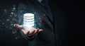 Data Management: Businessman\'s Hand Gently Presenting a Glowing Database Icon Royalty Free Stock Photo