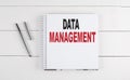 DATA MANAGEMENT text written on notebook on the wooden background Royalty Free Stock Photo