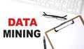 DATA MINING text written on white background with keyboard, paper sheet and pen Royalty Free Stock Photo