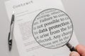 Data protection regulations of a contract are checked carefully with a magnifying glass Royalty Free Stock Photo