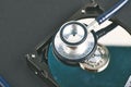 Stethoscope dusty dismantle hard disk over dark background