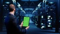 Database admin analyzing greenscreen display on tablet