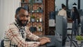 Database programer writing code and smiling while coworker walks by holding clipboard