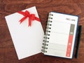 calendar diary planner with date of December and January in grid and envelope with red ribbon bow and pen on desk floor Royalty Free Stock Photo