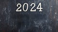 2024 date handwritten in a chalk writing text script on a wooden black chalkboard