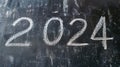 2024 date handwritten in a chalk writing text script on a wooden black chalkboard