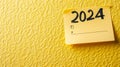 2024 date handwritten in a text script with a black marker pen on paper note pad memo placed on a yellow background Royalty Free Stock Photo