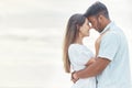 Date, love and couple at the beach hug, look in eyes and bonding together for anniversary, engagement or valentines day Royalty Free Stock Photo