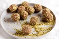 Date and nuts energy balls rolled in pumpkin seeds powder