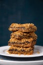 Date squares or Matrimonial cake stacked on a plate on a dark background