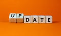 Date or update symbol. Turned wooden cubes and changed the concept word date to update. Beautiful orange table, orange background Royalty Free Stock Photo