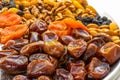 Dates, dried apricots, raisins lie on a silver tray on a white wooden background Royalty Free Stock Photo