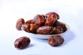 dates fruit image, arabic food, pile on small plate, isolated white background image Royalty Free Stock Photo