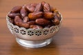 Dates fruit on a silver bowl on wooden table Royalty Free Stock Photo