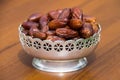 Dates fruit on a silver bowl on wooden table. The Muslim feast of holy month of Ramadan Kareem Royalty Free Stock Photo