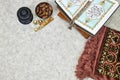 dates fruits and rosary, prayer mat with open muslim book with Arabic calligraphy Quran - translation : the noble book Royalty Free Stock Photo